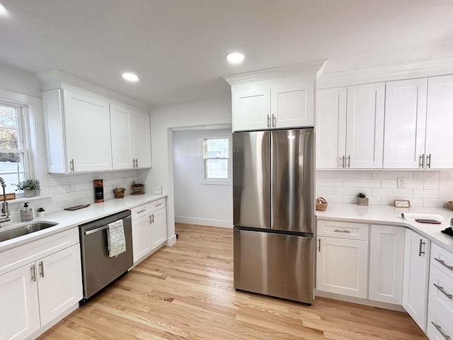 kitchen featuring sink, stainless steel appliances, and white cabinetry