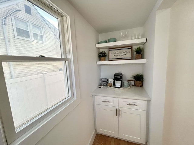 bar featuring hardwood / wood-style floors and white cabinetry