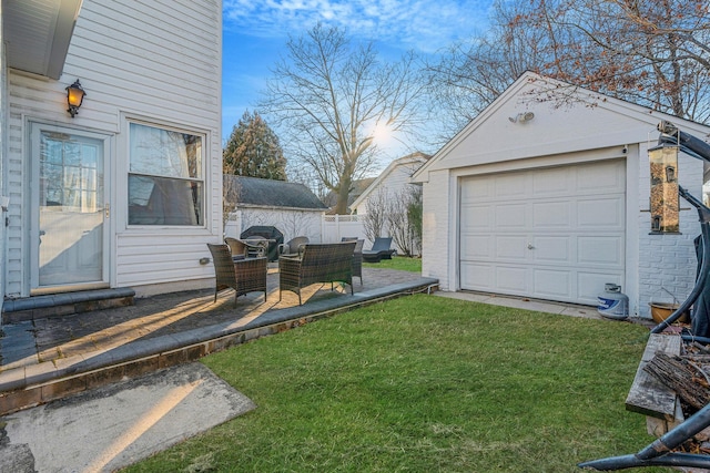 view of yard featuring an outbuilding, a detached garage, and fence