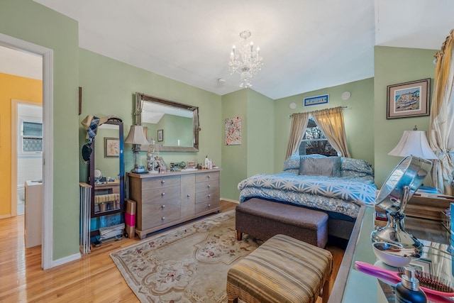 bedroom featuring lofted ceiling, a notable chandelier, light wood-style flooring, and baseboards