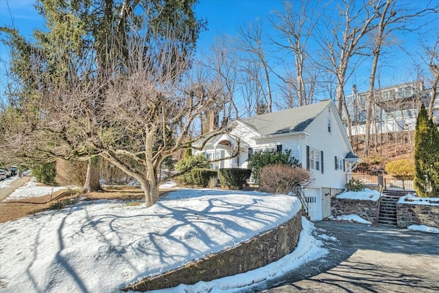 view of front of home with a garage, driveway, and stairway