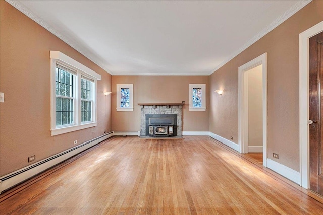 unfurnished living room with a baseboard heating unit, light wood-type flooring, baseboards, and crown molding