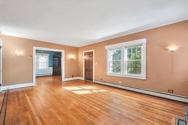 unfurnished living room featuring a baseboard heating unit, light wood-type flooring, and baseboards