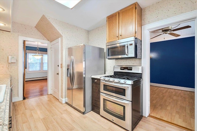 kitchen featuring wallpapered walls, stainless steel appliances, light countertops, light wood-type flooring, and a baseboard heating unit