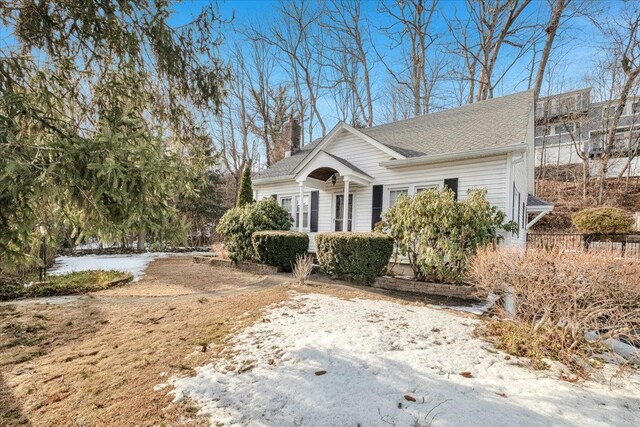 view of front of property featuring roof with shingles and a chimney