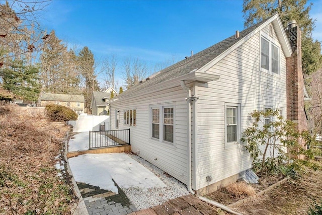 view of property exterior with a patio area and fence