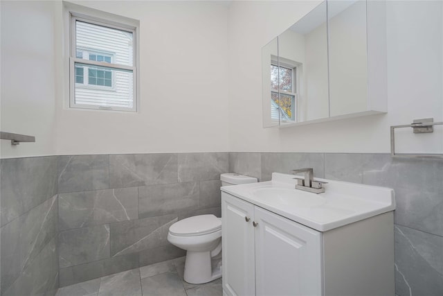 bathroom featuring tile walls, vanity, toilet, and tile patterned floors