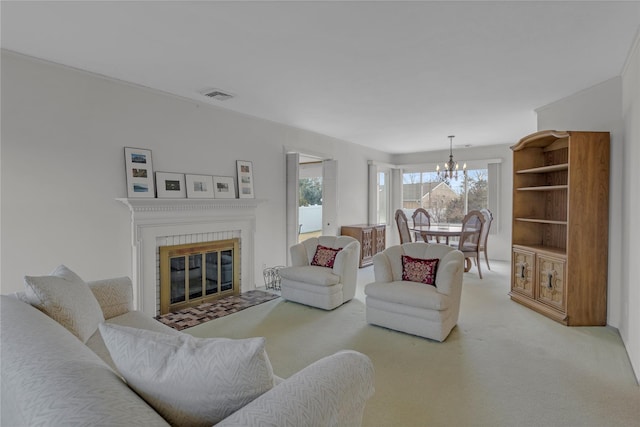 living room with carpet, a glass covered fireplace, visible vents, and an inviting chandelier