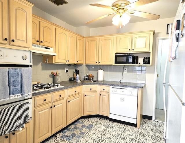 kitchen with under cabinet range hood, white appliances, tasteful backsplash, and light brown cabinetry