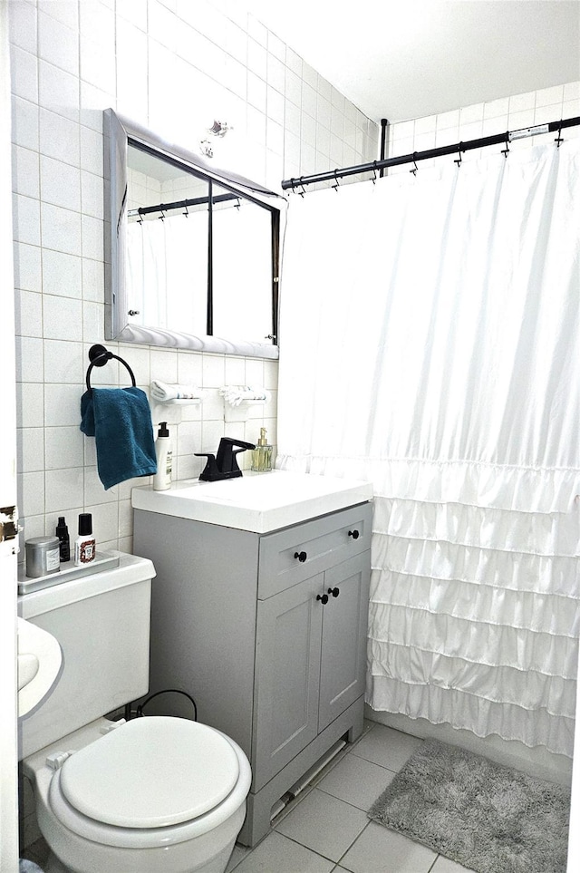 bathroom featuring tile patterned floors, toilet, tile walls, and vanity