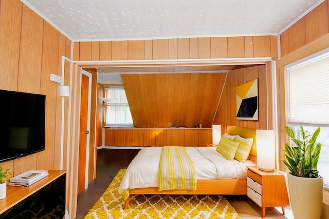 bedroom with dark hardwood / wood-style floors and wood walls