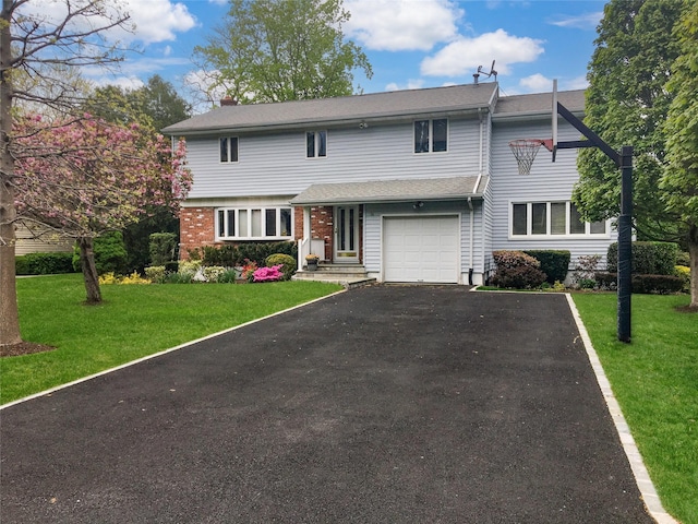 traditional home with a garage, driveway, brick siding, and a front yard