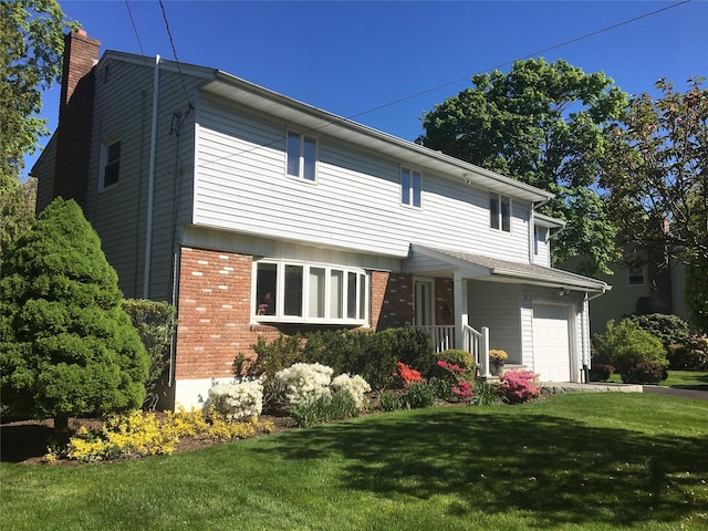 back of house with a garage, brick siding, a lawn, and a chimney