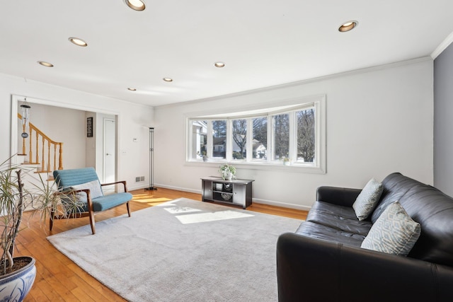 living room with recessed lighting, baseboards, ornamental molding, stairway, and light wood-type flooring