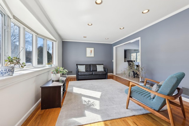 living area with recessed lighting, crown molding, baseboards, and wood finished floors