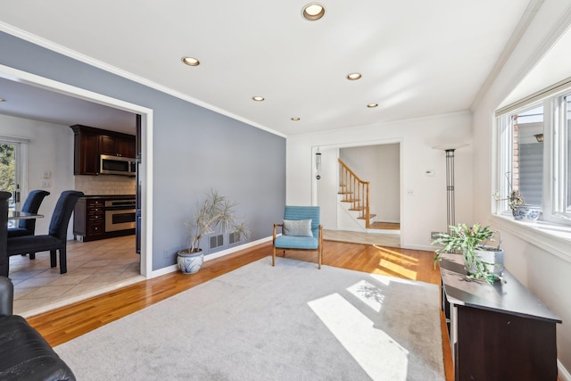 interior space featuring stairs, ornamental molding, light wood-style flooring, and recessed lighting