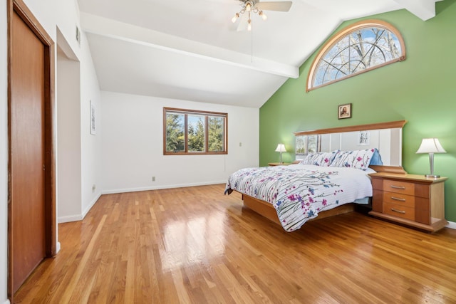 bedroom with light wood-type flooring, beam ceiling, and multiple windows