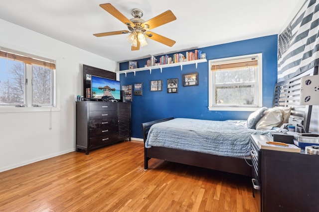 bedroom featuring light wood-style floors, baseboards, and a ceiling fan