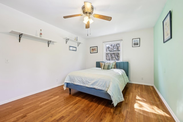 bedroom featuring ceiling fan, baseboards, and wood finished floors