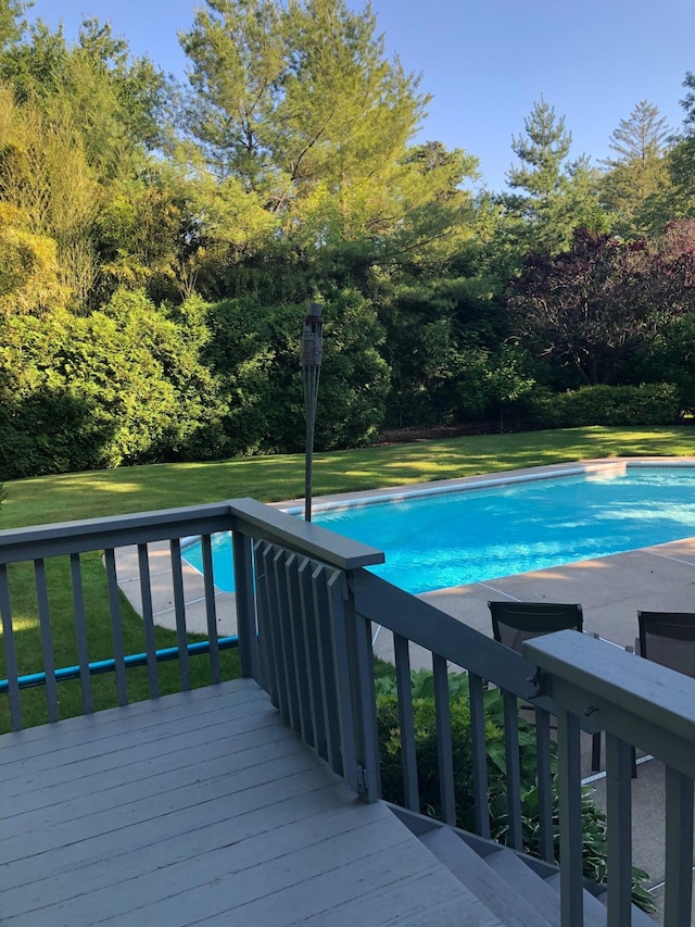 pool featuring a deck and a lawn