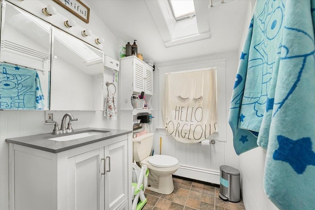 bathroom featuring vanity, a skylight, toilet, and a baseboard radiator