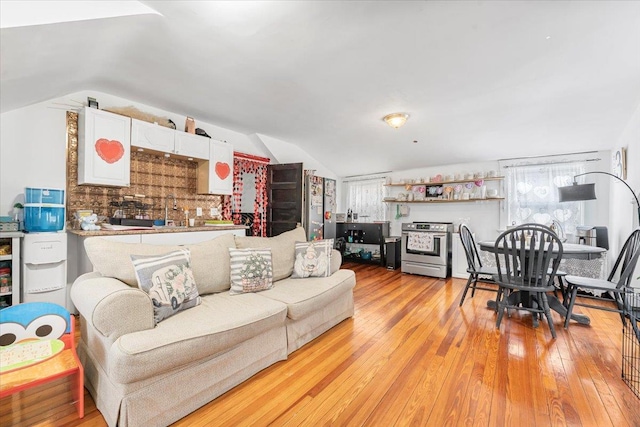 living room with vaulted ceiling and light hardwood / wood-style flooring