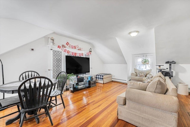 living room with hardwood / wood-style flooring, vaulted ceiling, and a baseboard radiator