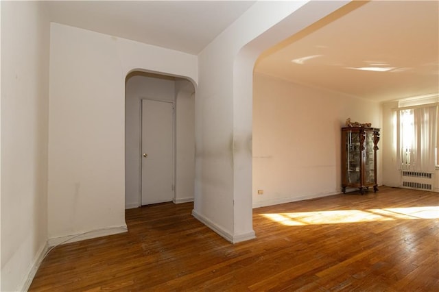 spare room with radiator and dark wood-type flooring