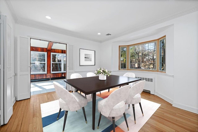 dining area with ornamental molding, recessed lighting, light wood-style flooring, and radiator heating unit