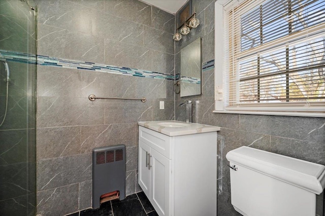 bathroom featuring radiator, toilet, tile walls, and vanity