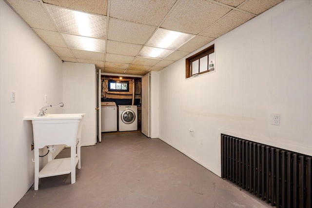 clothes washing area featuring laundry area, separate washer and dryer, and radiator