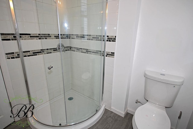 bathroom featuring toilet, walk in shower, and hardwood / wood-style floors