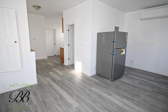 interior space with hardwood / wood-style flooring and a wall unit AC