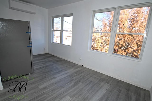 unfurnished room featuring dark hardwood / wood-style flooring and an AC wall unit