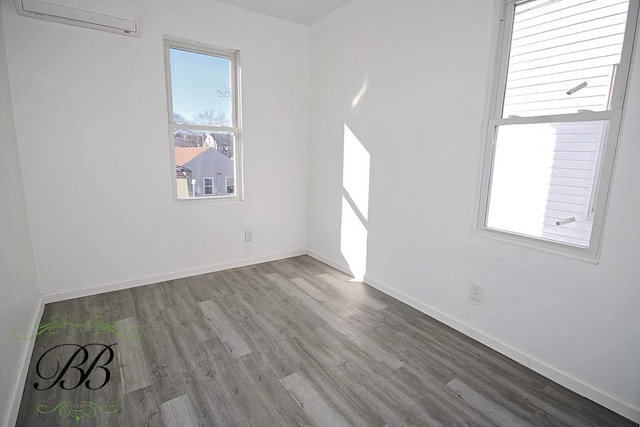 empty room with hardwood / wood-style flooring and a wall mounted air conditioner