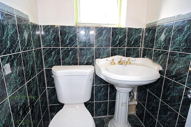 bathroom with tile walls and toilet