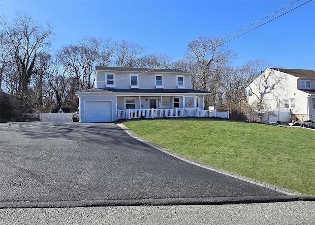 view of front of property with aphalt driveway, covered porch, fence, a garage, and a front lawn