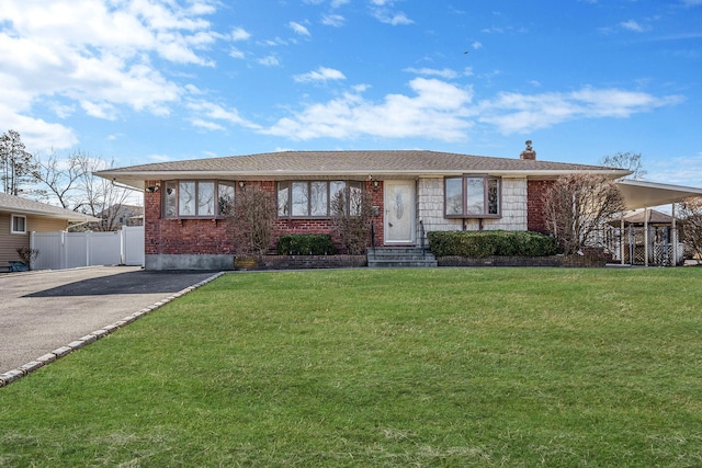 single story home featuring driveway, a chimney, fence, a front yard, and brick siding