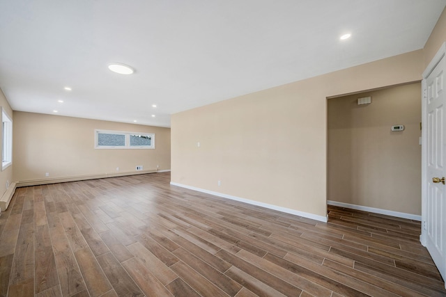 unfurnished room featuring recessed lighting, dark wood finished floors, baseboards, and a baseboard radiator