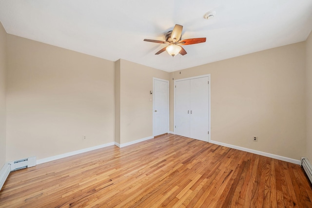 empty room featuring light wood-style floors, a baseboard radiator, baseboards, and a ceiling fan