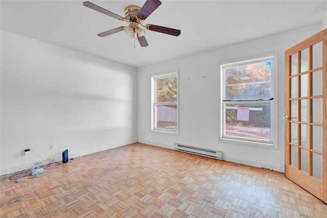 unfurnished room with ceiling fan, a baseboard heating unit, and light parquet flooring