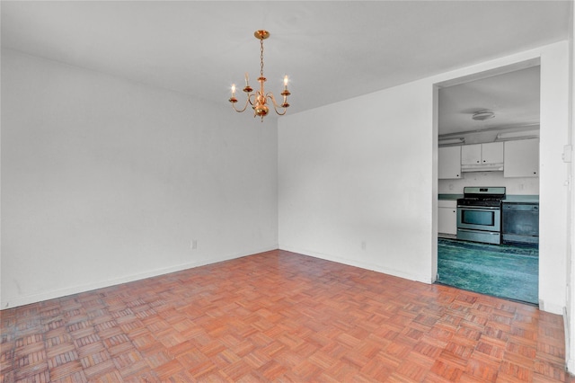 spare room featuring a chandelier and light parquet flooring