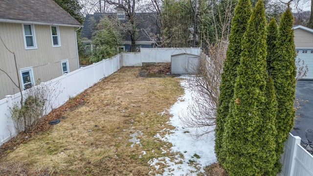 view of yard featuring a fenced backyard, a storage unit, and an outdoor structure