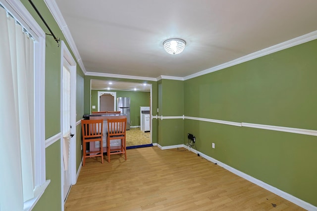 interior space with baseboards, ornamental molding, and wood finished floors