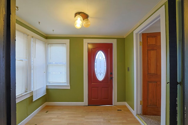 entrance foyer with a healthy amount of sunlight, light wood finished floors, baseboards, and crown molding