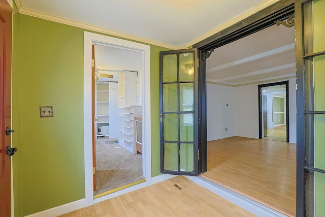 interior space with wood finished floors and crown molding