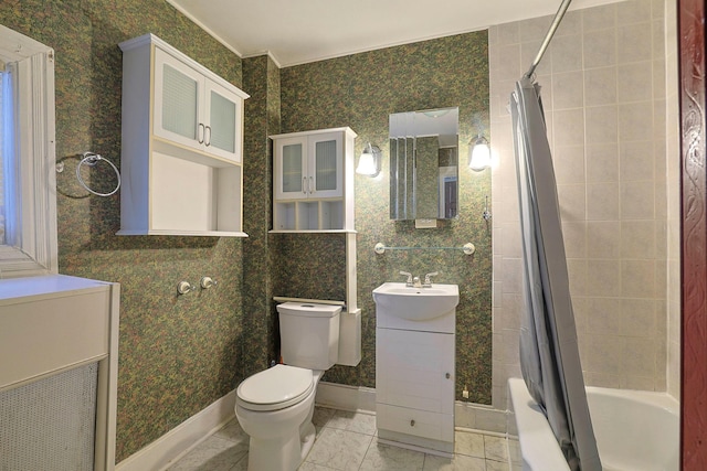 bathroom featuring vanity, shower / bath combo with shower curtain, toilet, and baseboards