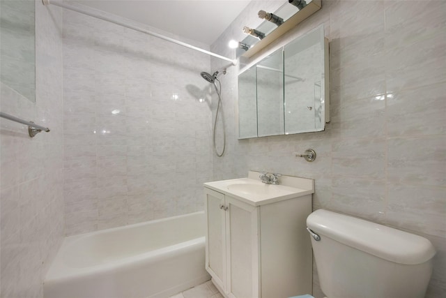 full bathroom featuring tile walls, vanity, tiled shower / bath combo, toilet, and tile patterned floors