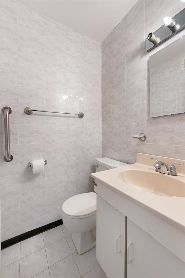 bathroom with tile walls, vanity, tile patterned flooring, and toilet