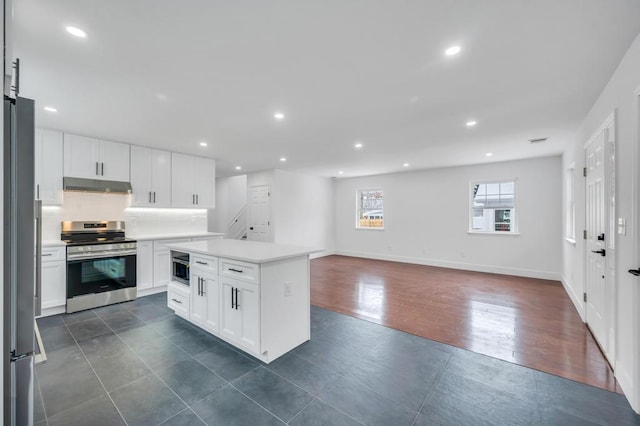 kitchen featuring appliances with stainless steel finishes, a kitchen island, dark hardwood / wood-style flooring, and white cabinets